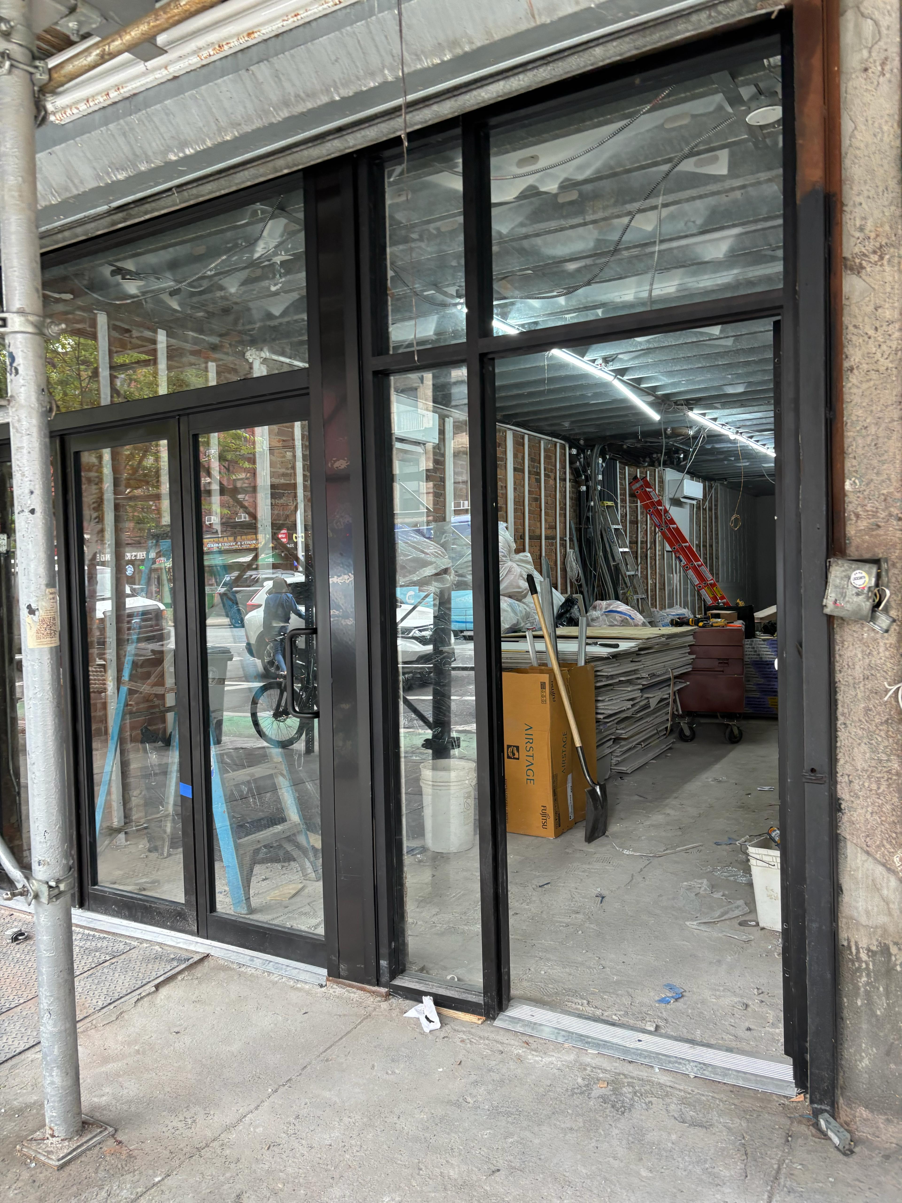 Commercial storefront glass installation with black aluminum frames in Brooklyn NY